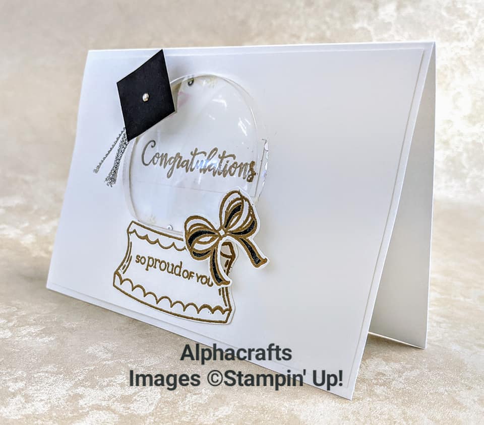 Graduation card using the Zoo Globe stamp set and coordinating Snow Globe Scenes Dies from Stampin' Up!. The card is white and has a plastic dome attached with a graduation cap and a bow. The words Congratulations, so proud of you are shown in gold.