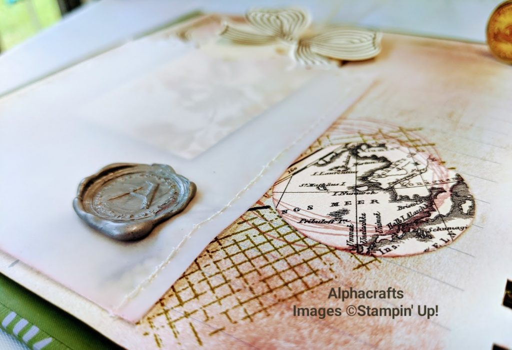 Close up image of the page that has a wax seal and a vellum pocket that's been stitched to the page. It also shows a map.